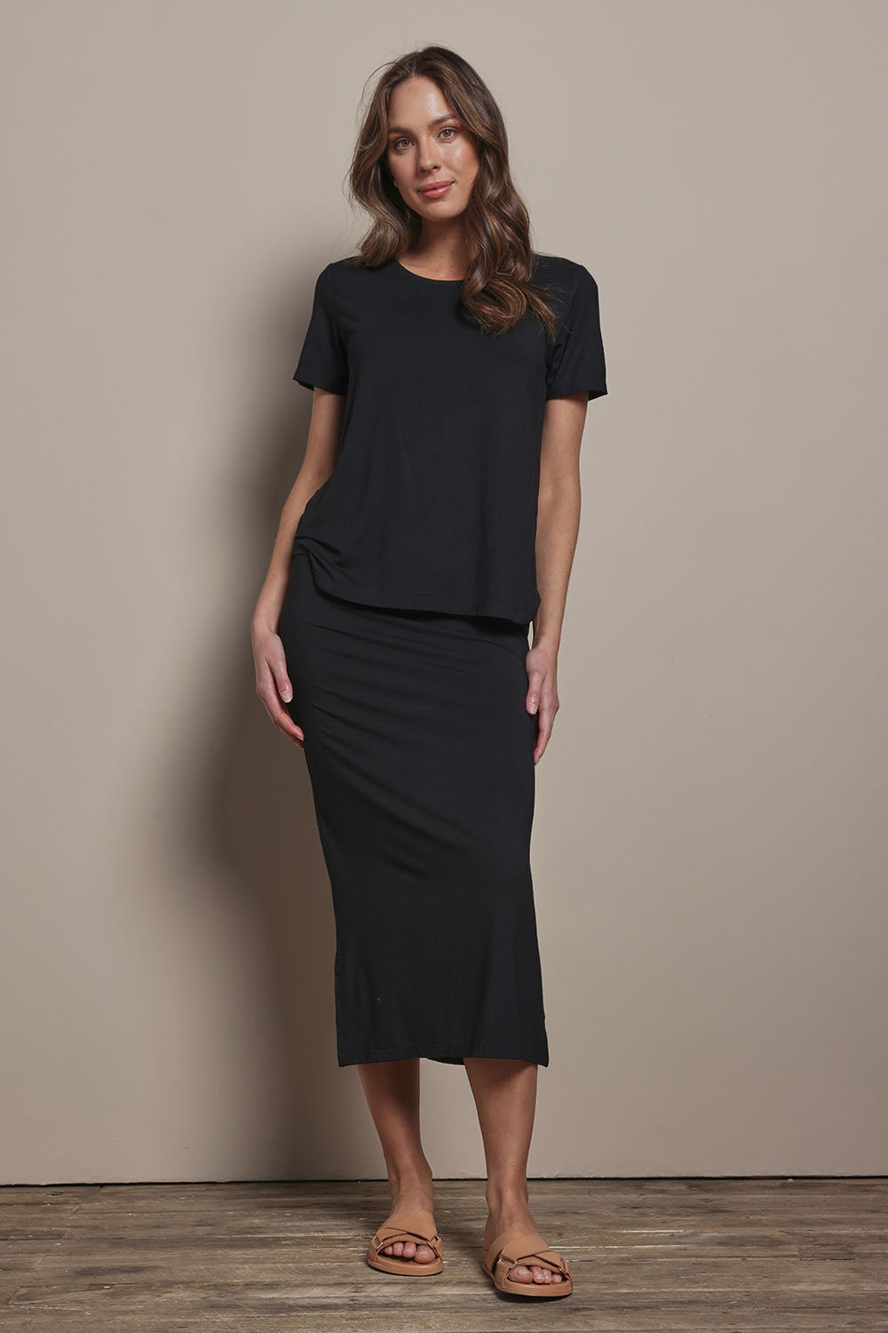 Model Madeline wearing size 10 of The Pack & Go Luxe Bamboo Pull On Maxi Skirt in colour Black (Black), from the front, showing the whole outfit
