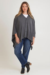Model Chanel wearing The Pack & Go Luxe Bamboo Shrug in colour Charcoal (Grey), from the front, showing the whole outfit