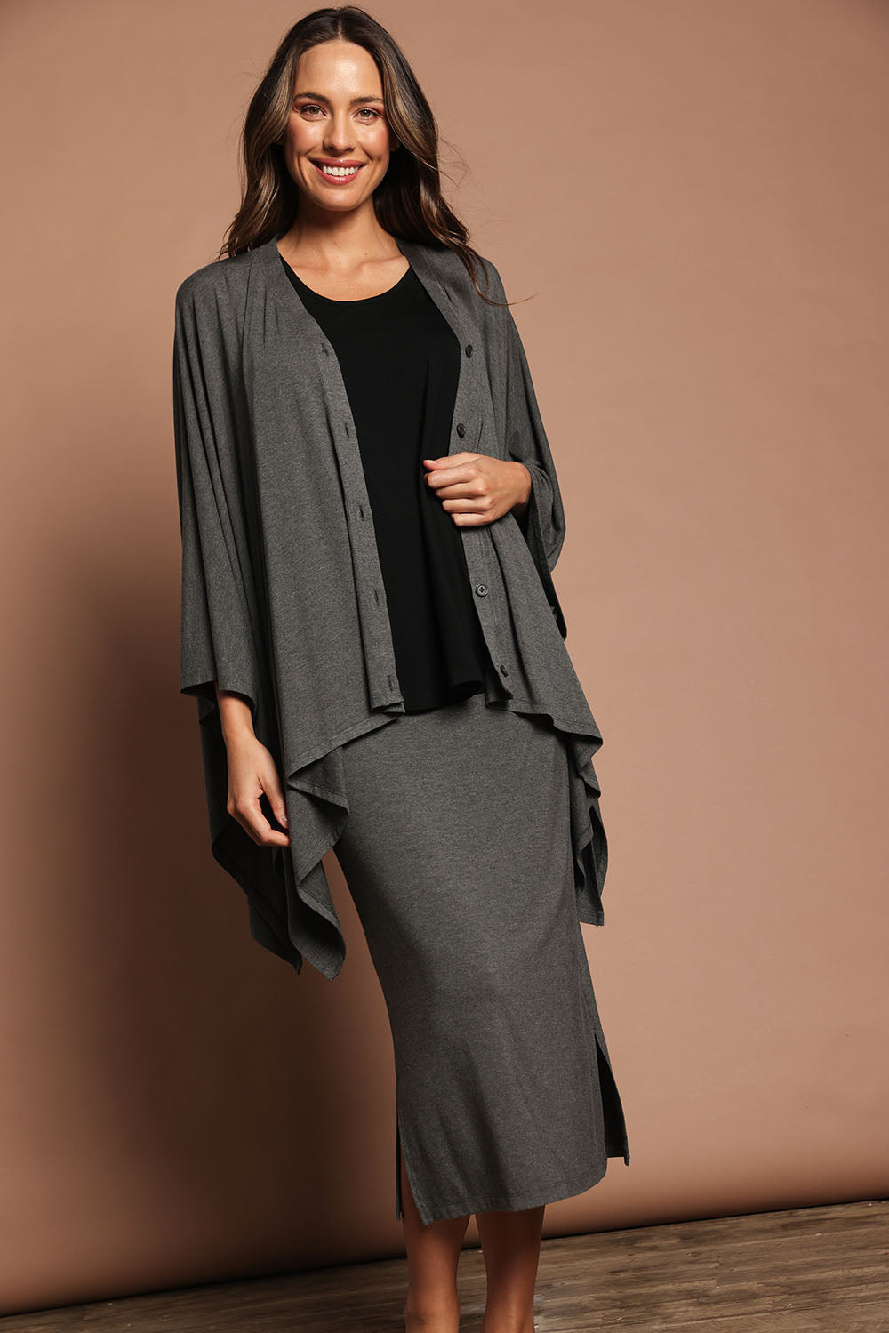 Model Madeline wearing The Pack & Go Luxe Bamboo Shrug in colour Charcoal (Grey), from the front, showing the whole outfit