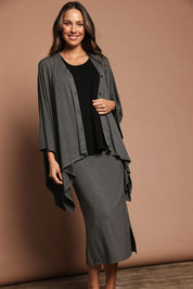 Model Madeline wearing The Pack & Go Luxe Bamboo Shrug in colour Charcoal (Grey), from the front, showing the whole outfit