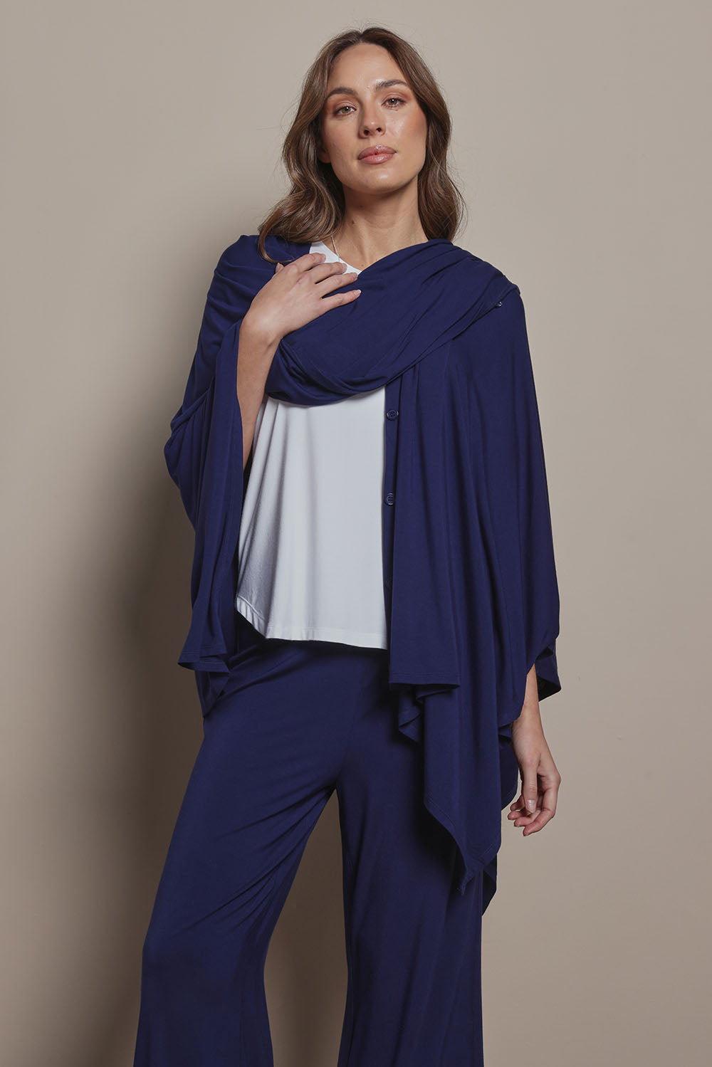 Model Madeline wearing The Pack & Go Luxe Bamboo Shrug in colour Frenchnavy (Blue), from the front, cropped image
