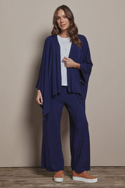 Model Madeline wearing The Pack & Go Luxe Bamboo Shrug in colour Frenchnavy (Blue), from the front, showing the whole outfit
