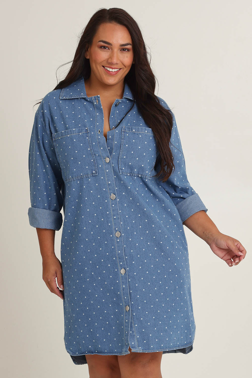 Model Ashleigh wearing size 16 of The Printed Denim Shacket Dress With Pockets in colour Denimspot (Blue), from the front, cropped image
