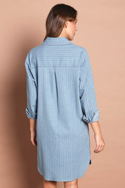 Model Madeline wearing size 10 of The Printed Denim Shacket Dress With Pockets in colour Denimstrip (Blue), from the back
