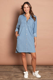 Model Madeline wearing size 10 of The Printed Denim Shacket Dress With Pockets in colour Denimstrip (Blue), from the front, showing the whole outfit
