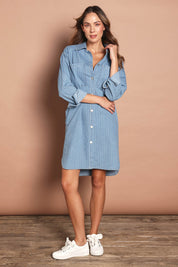 Model Madeline wearing size 10 of The Printed Denim Shacket Dress With Pockets in colour Denimstrip (Blue), from the front, showing the whole outfit