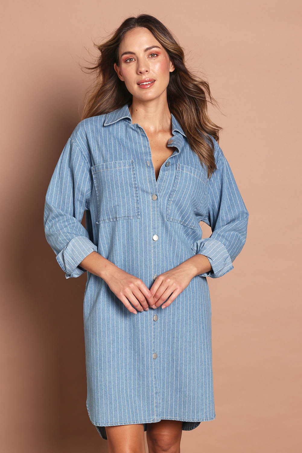 Model Nathalie wearing size 10 of The Printed Denim Shacket Dress With Pockets in colour Denimstrip (Blue), from the front, cropped image