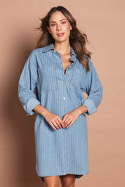 Model Nathalie wearing size 10 of The Printed Denim Shacket Dress With Pockets in colour Denimstrip (Blue), from the front, cropped image