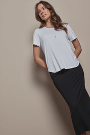 Model Madeline wearing size 10 of The Pack & Go Luxe Bamboo Tee in colour White (White), from the front, cropped image