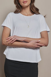 Model Madeline wearing size 10 of The Pack & Go Luxe Bamboo Tee in colour White (White), from the front, cropped image