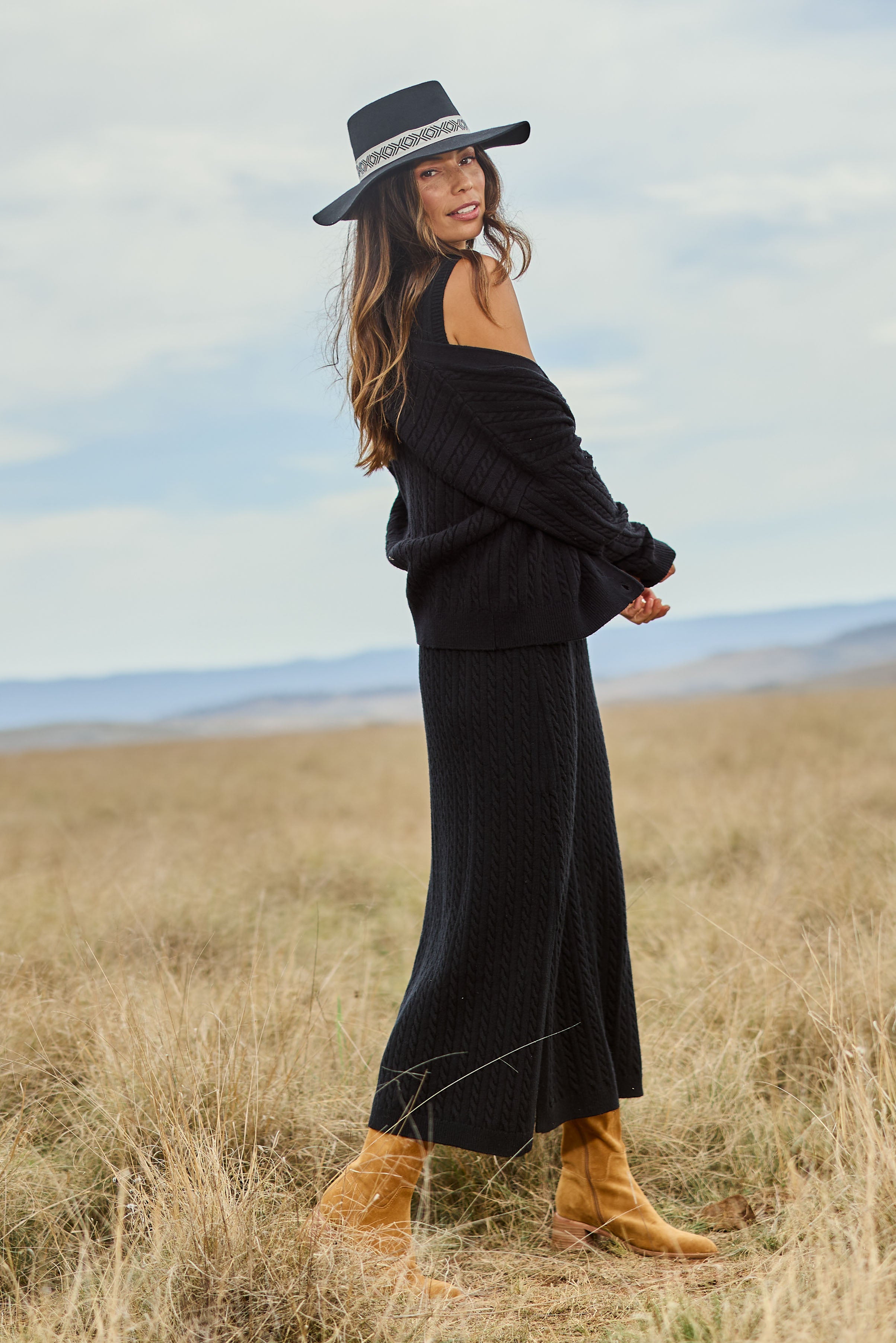 Model Amanda wearing size S of The Cable Knit Button Up Cardigan in colour Black (Black), from the front, showing the whole outfit