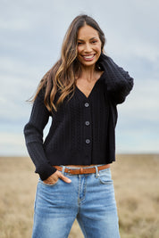 Model Amanda wearing size S of The Cable Knit Button Up Cardigan in colour Black (Black), from the front, showing the whole outfit