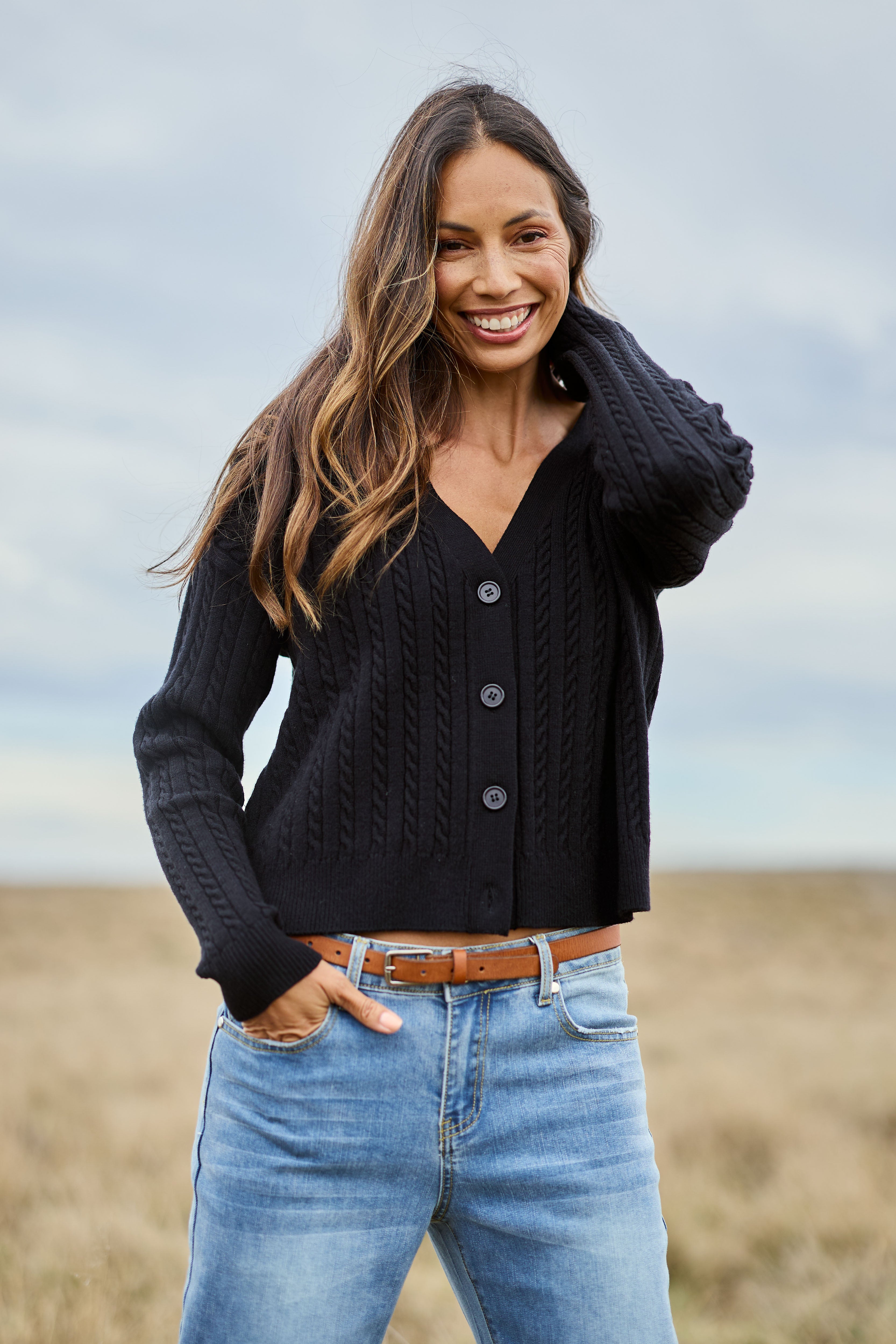 Model Amanda wearing size S of The Cable Knit Button Up Cardigan in colour Black (Black), from the front, showing the whole outfit