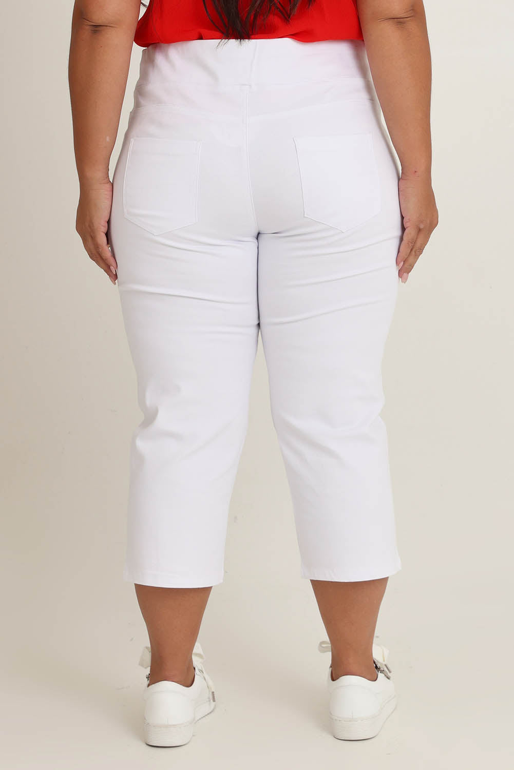 Model Ashleigh wearing size 16 of The Pull On Cotton Cropped Pant With Pockets in colour White (White), from the back