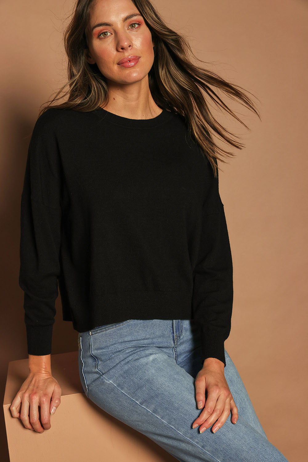 Model Madeline wearing size S of The Essential Cropped Modal Blend Jumper in colour Black (Black), from the front, cropped image