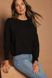 Model Madeline wearing size S of The Essential Cropped Modal Blend Jumper in colour Black (Black), from the front, cropped image