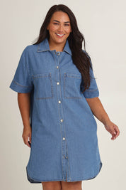 Model Ashleigh wearing size 16 of The S/S Chambray Shacket Dress With Pockets in colour Lightdenim (Blue), from the front, cropped image