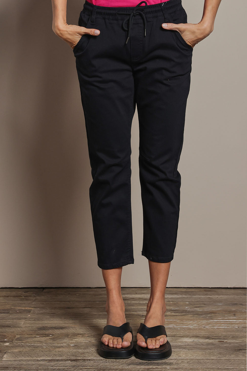 Model Amanda wearing size 10 of The Pull On Cotton Pant With Drawstring in colour Black (Black), from the front, cropped image