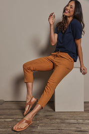 Model Amanda wearing size 10 of The Pull On Cotton Pant With Drawstring in colour Rust, from the front, showing the whole outfit