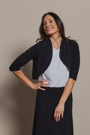 Model Amanda wearing size 10 of The Mix Me Match Me Bamboo Shrug in colour Black (Black), from the front, cropped image
