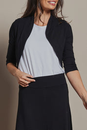 Model Amanda wearing size 10 of The Mix Me Match Me Bamboo Shrug in colour Black (Black), from the front, cropped image