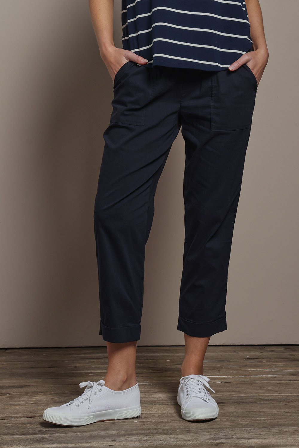 Model Madeline wearing size 10 of The Elastic Waist Pull On Patch Pocket Pant in colour Navy (Blue), from the front, cropped image