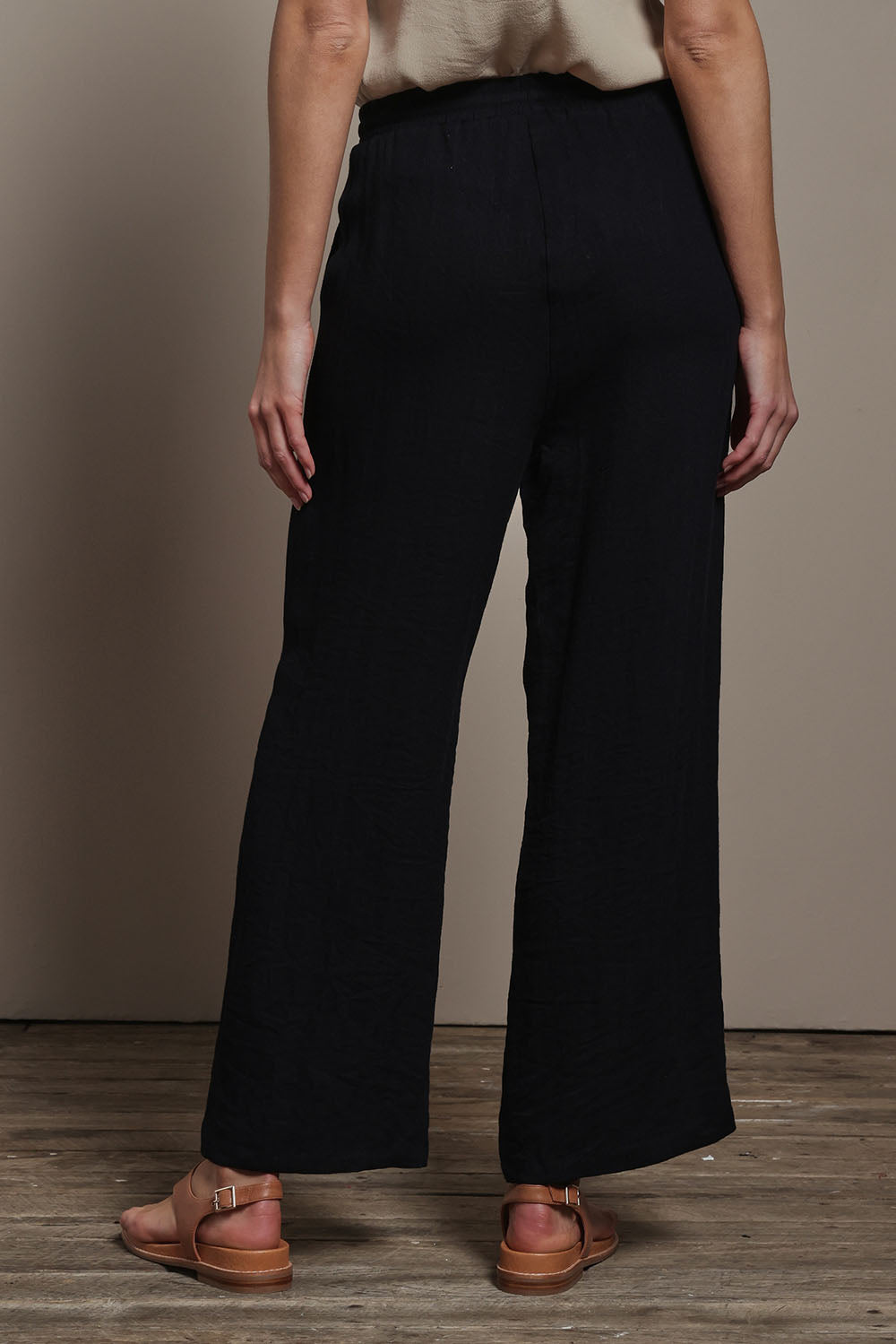 Model Madeline wearing size 10 of The Must Have Linen Look Pull on Pant in colour Black (Black), from the back