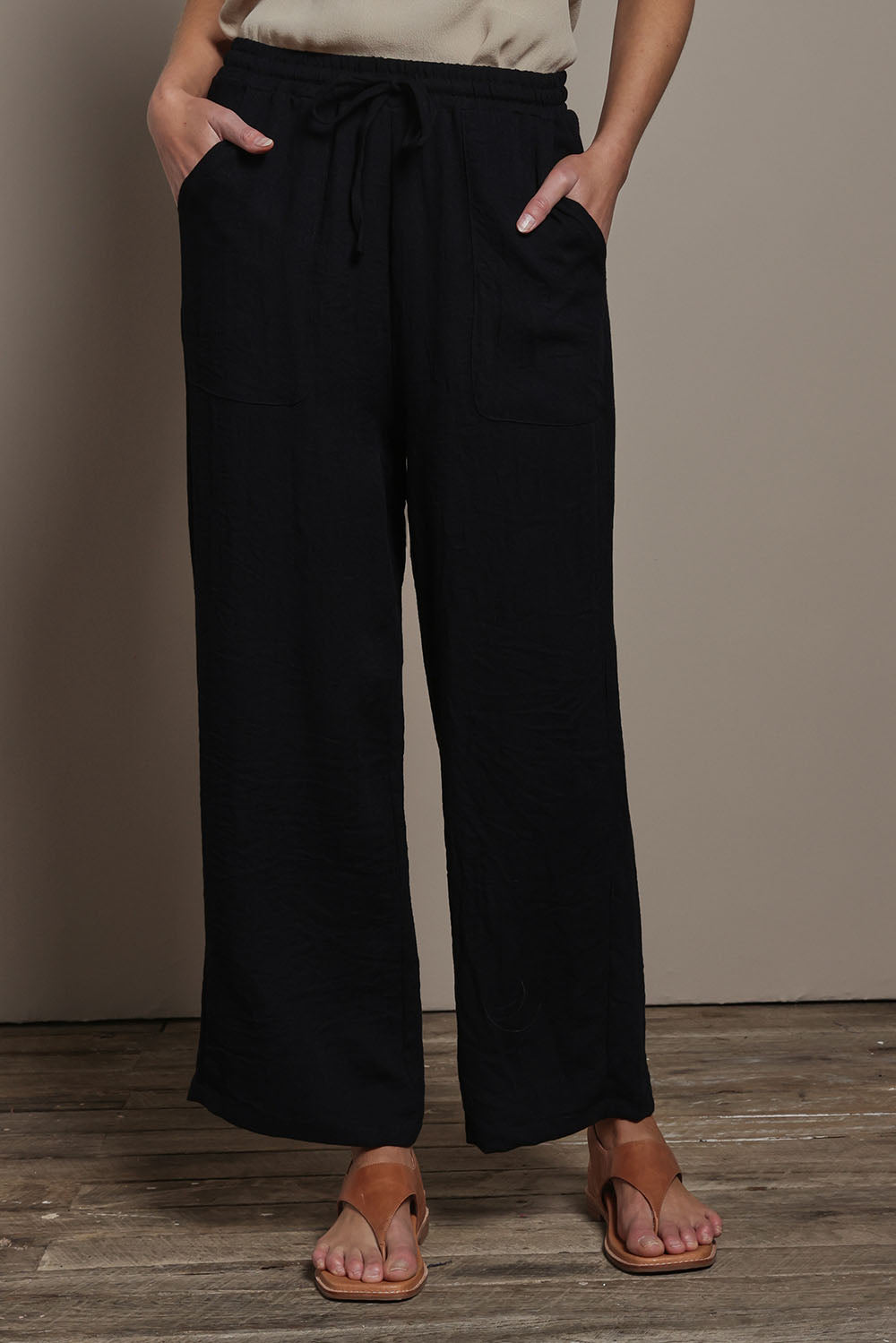 Model Madeline wearing size 10 of The Must Have Linen Look Pull on Pant in colour Black (Black), from the front, cropped image