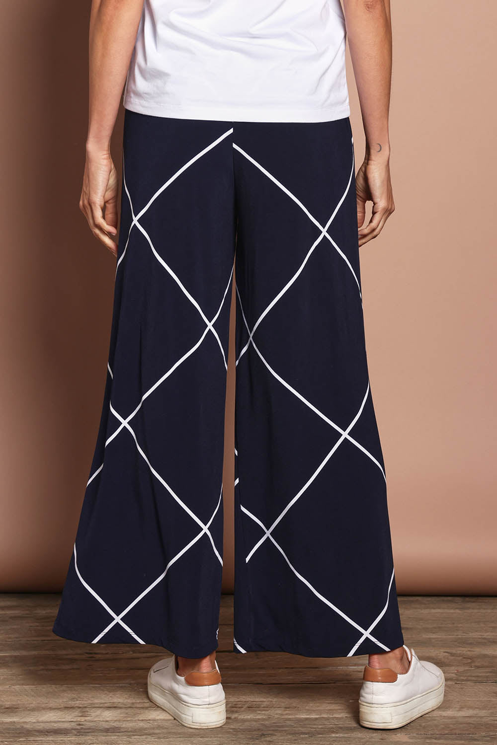 Model Amanda wearing size 10 of The Easy Wear Printed Pull On Wide Leg Pant in colour Navywhite (Blue), from the back