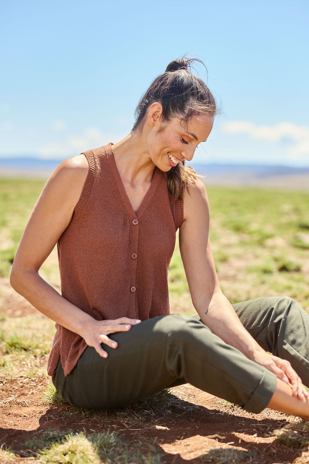 Model Amanda wearing size S of The Every Wear Knit Button Up Vest in colour Brick, from the front, showing the whole outfit