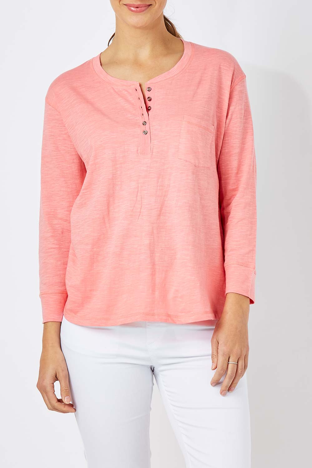 Model Anna wearing size 10 of The Relaxed Henley Tee in colour Coral (Pink), from the front, cropped image