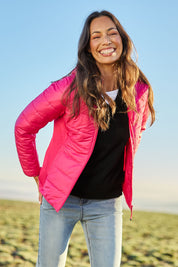 Model Amanda wearing size S of The Keepers Puffer Jacket in colour Hotpink (Pink), from the front, showing the whole outfit