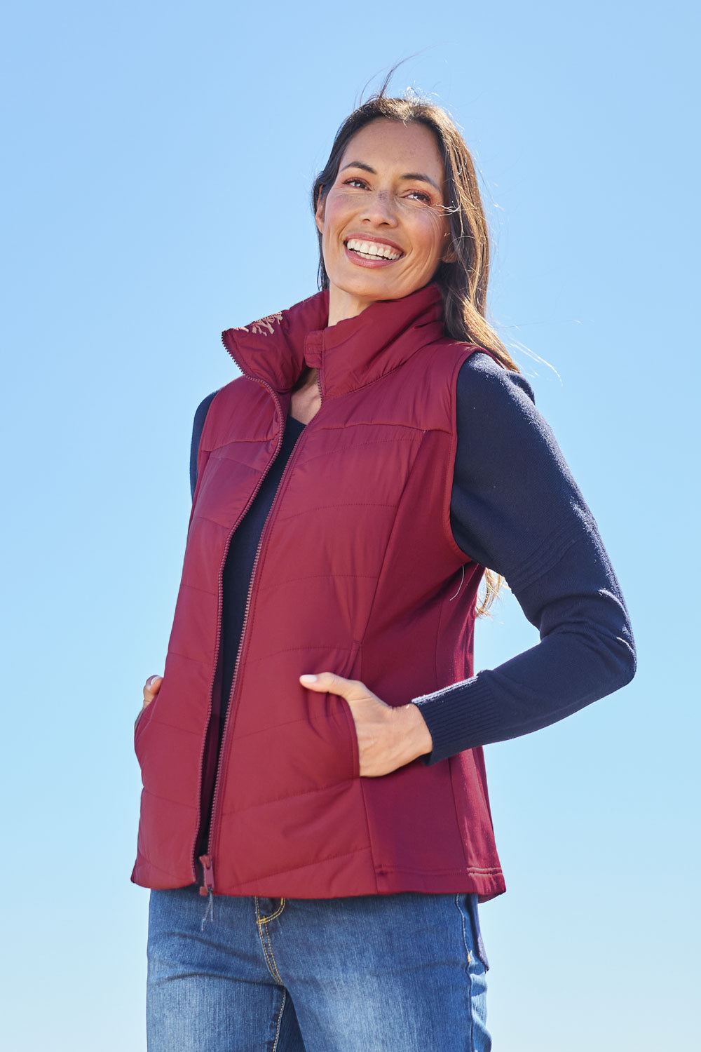 Model Amanda wearing size S of The Keepers Puffer Vest in colour Wine (Red), from the front, showing the whole outfit