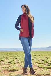 Model Amanda wearing size S of The Keepers Puffer Vest in colour Wine (Red), from the front, showing the whole outfit