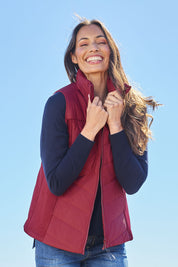 Model Amanda wearing size S of The Keepers Puffer Vest in colour Wine (Red), from the front, showing the whole outfit