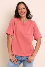 Model Amandam wearing size 10 of the The Keepers Relaxed Fit Tee – Papaya in colour Papaya, in a cropped view
