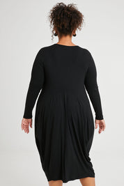 Model Alexis wearing size 16 of The Bounce Dress in colour Black (Black), from the back