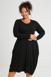 Model Alexis wearing size 16 of The Bounce Dress in colour Black (Black), from the front, cropped image