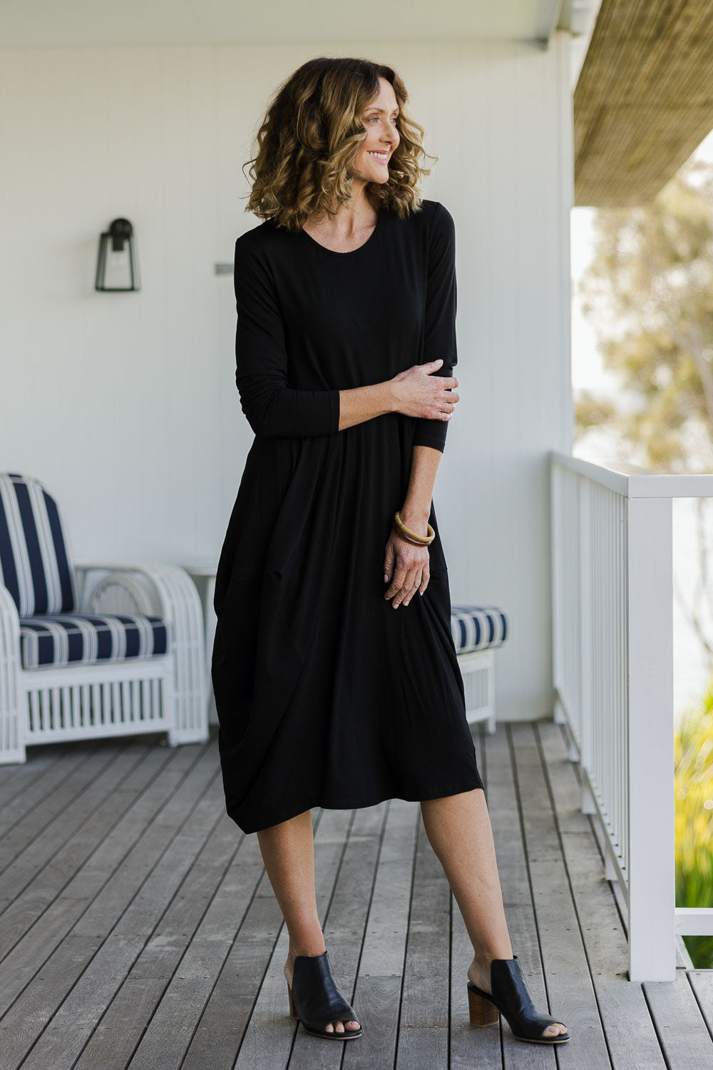 Model Emma wearing size 10 of The Bounce Dress in colour Black (Black), from the front, showing the whole outfit