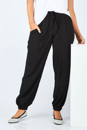 Model Laura wearing size 14 of The Soft Utility Pant in colour Black (Black), from the front, cropped image