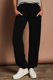 Model Madeline wearing size 10 of The Soft Utility Pant in colour Black (Black), from the front, cropped image