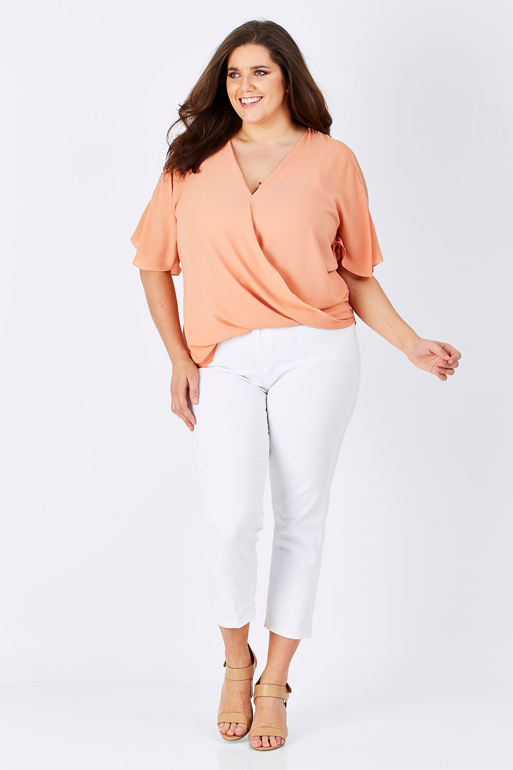 Model Mae wearing size 16 of The Cut Out Shoulder Blouse in colour Clay, from the front, showing the whole outfit