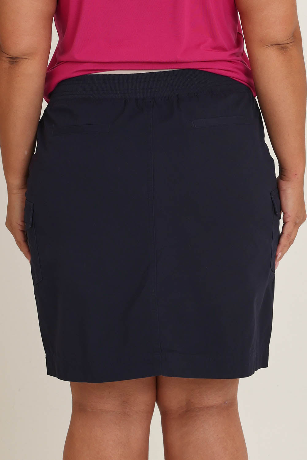 Model Ashleigh wearing size 16 of The Cotton Cargo Skirt in colour Navy (Blue), from the back