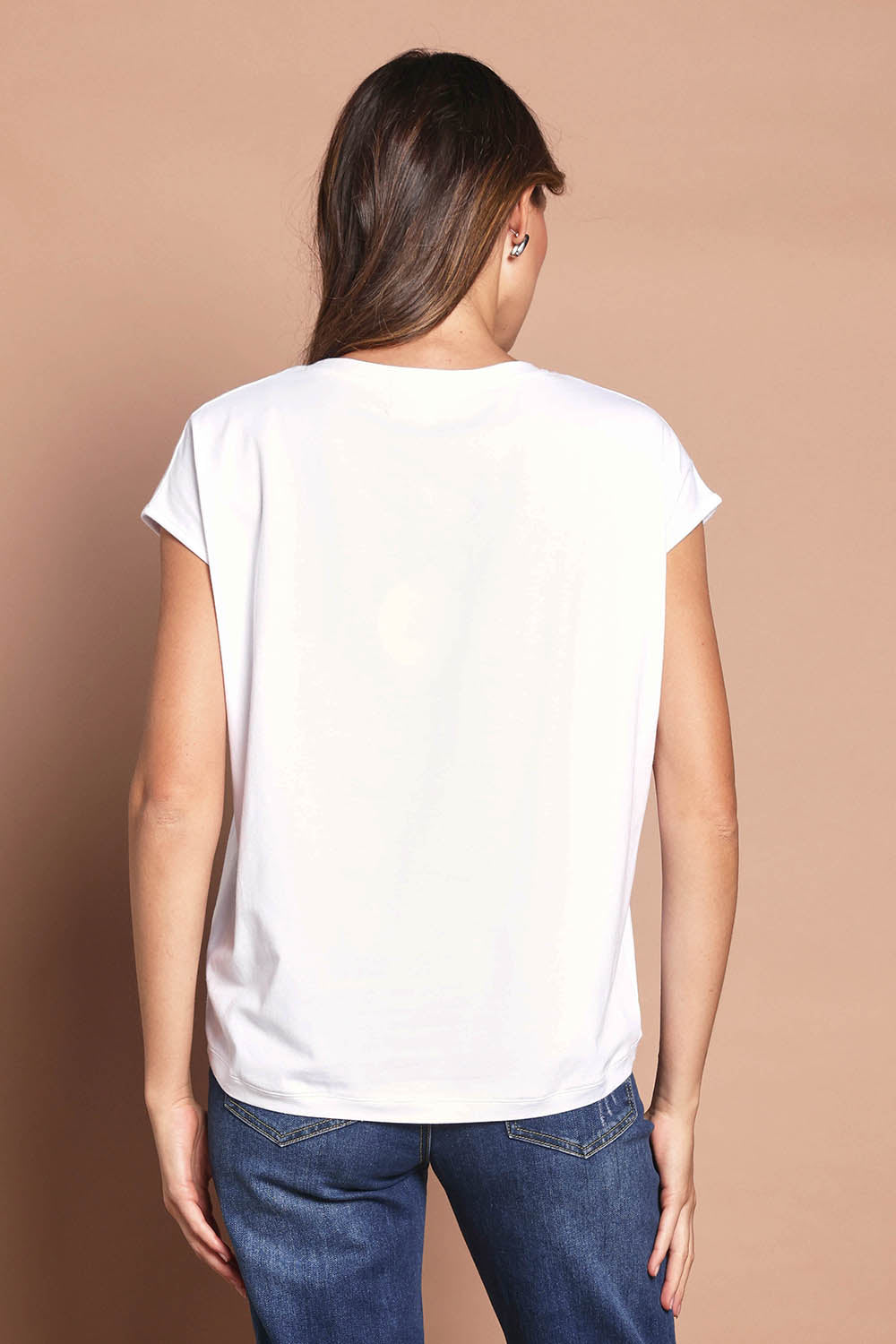 Model Madeline wearing size 10 of The Drape Tee in colour White (White), from the back