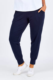 Model Laura wearing size 12 of The Basic Keeper Pant in colour Ink (Blue), from the front, cropped image
