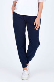 Model Riina wearing size 10 of The Basic Keeper Pant in colour Ink (Blue), from the front, cropped image
