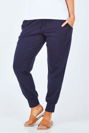 Model Laura wearing size 14 of The Basic Keeper Pant in colour Navy (Blue), from the front, cropped image