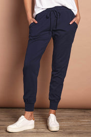 Model Madeline wearing size 10 of The Basic Keeper Pant in colour Navy (Blue), from the front, cropped image