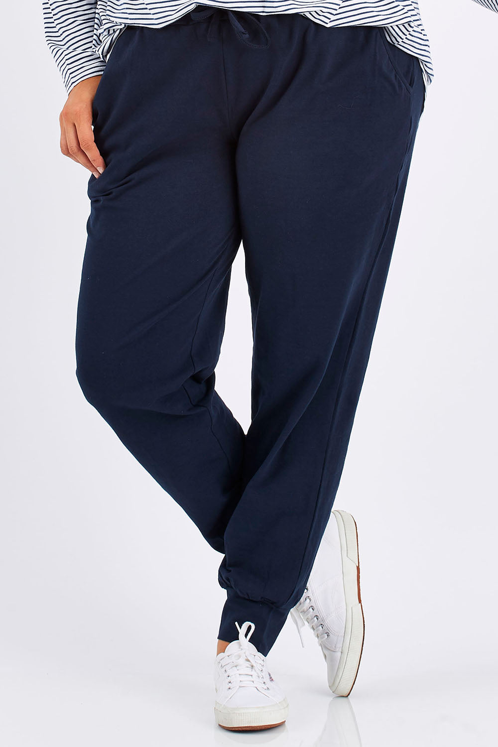 Model Mae wearing size 18 of The Basic Keeper Pant in colour Navy (Blue), from the front, cropped image