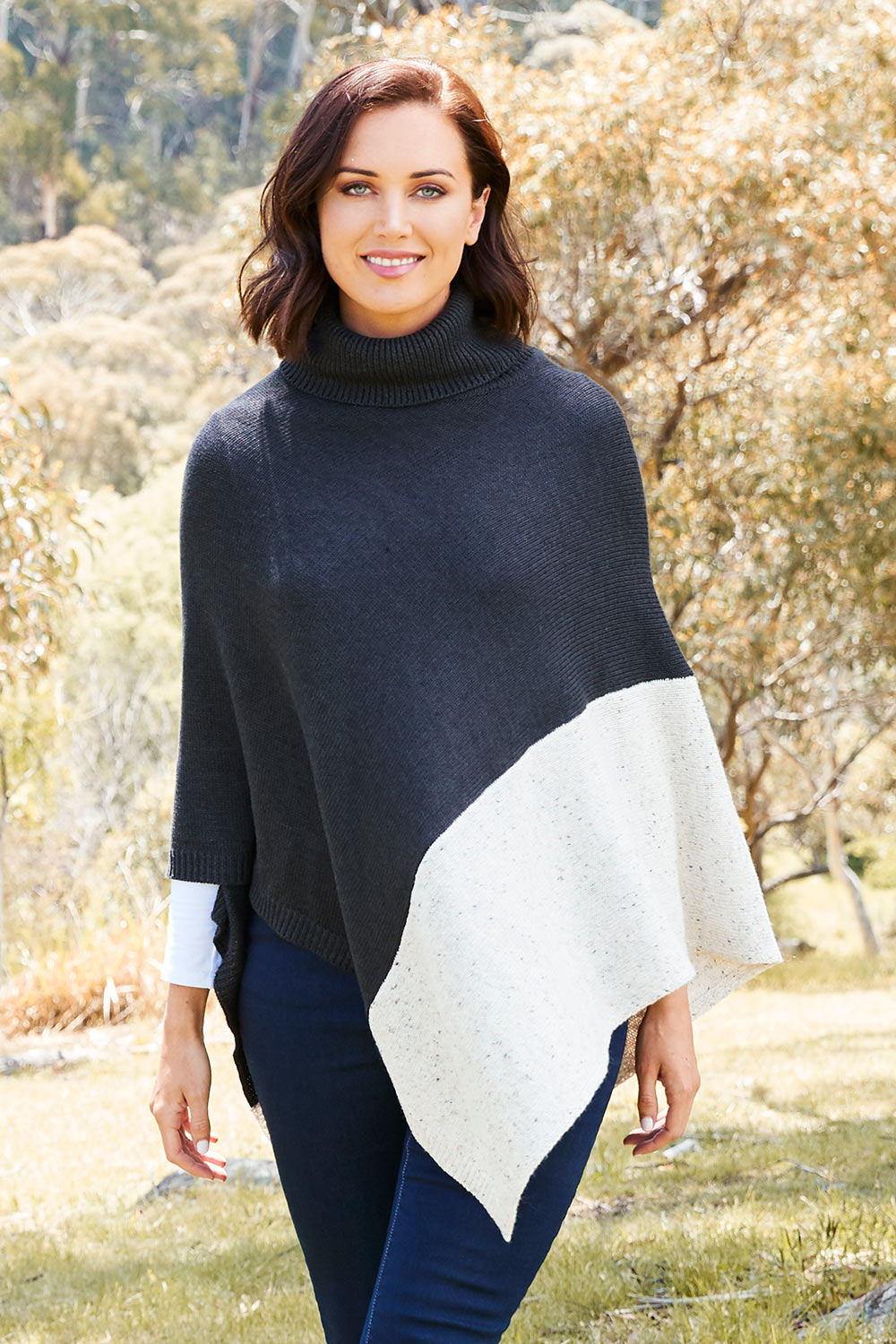 Model Perrie wearing The Panel Knit Poncho in colour Charcoal (Black), from the front, showing the whole outfit